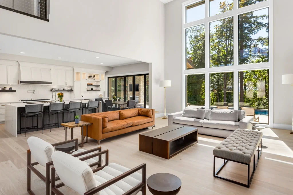 Modern great room with a two-story wall of tall white windows