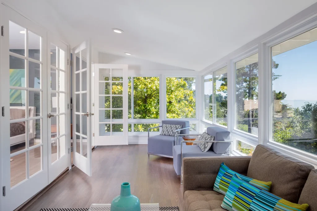 Bright sunroom with white windows and French doors