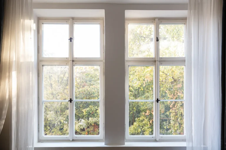Classic white double-hung windows with sheer curtains
